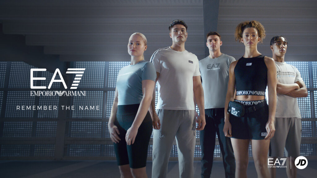 3 young male athletes and 2 young female athletes dressed in EA7 activewear stand in an industrial multi-storey car park, with the EA7 logo overlaid along with the headline REMEMBER THE NAME