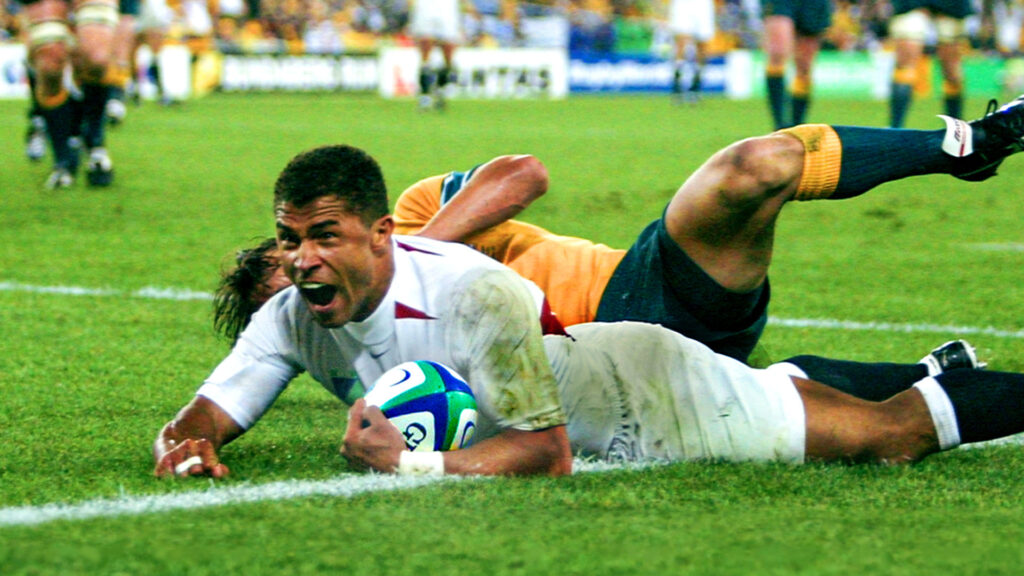 Jason Robinson scoring a try in the 2003 Rugby World Cup Final holding a Gilbert rugby ball.