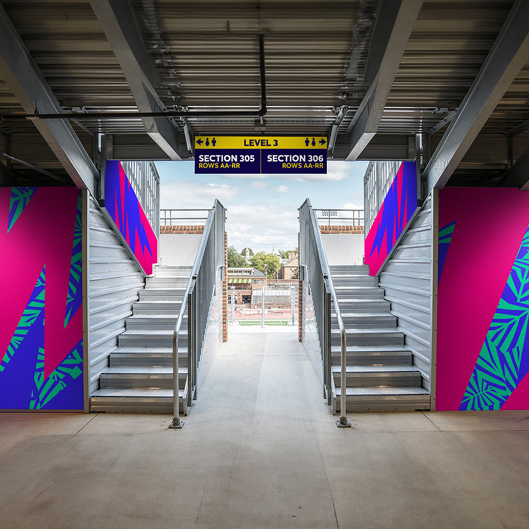 ICC T20 pink blue and purple brand graphics shown in-situ in a stadium stairwell area