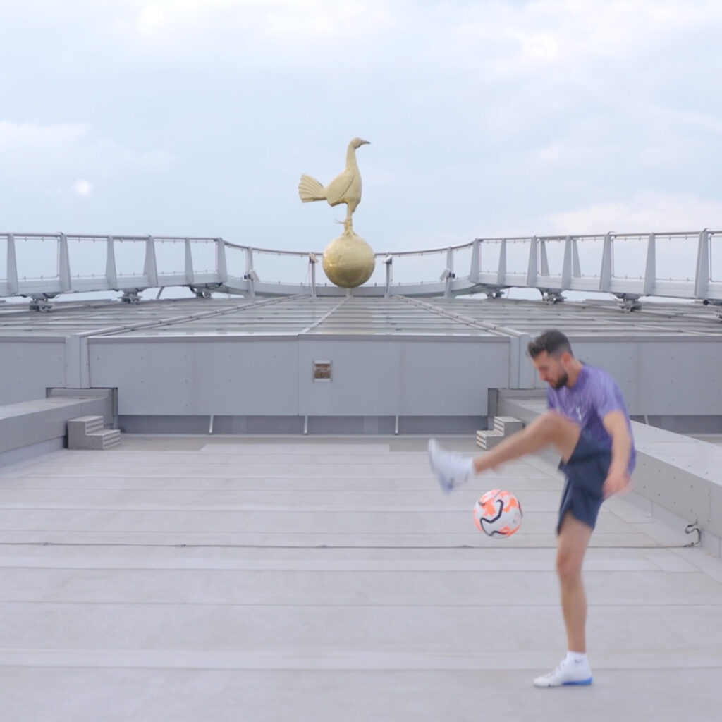 Football freestyler performing football tricks on top of Tottenham Hotspur stadium