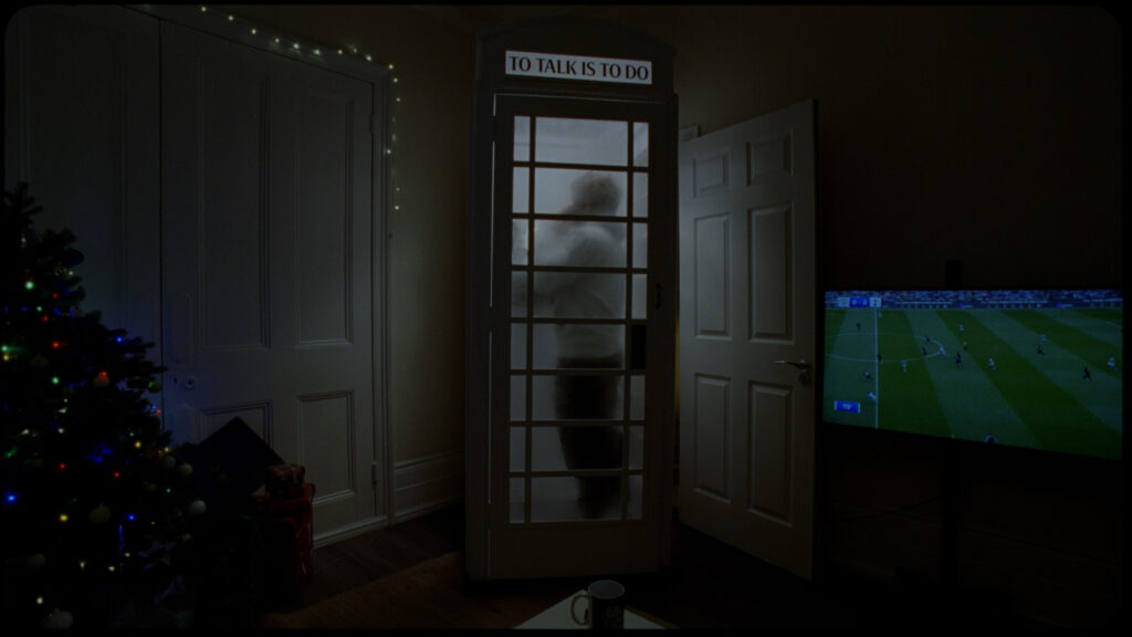 man in phone box calling for help with samaritans