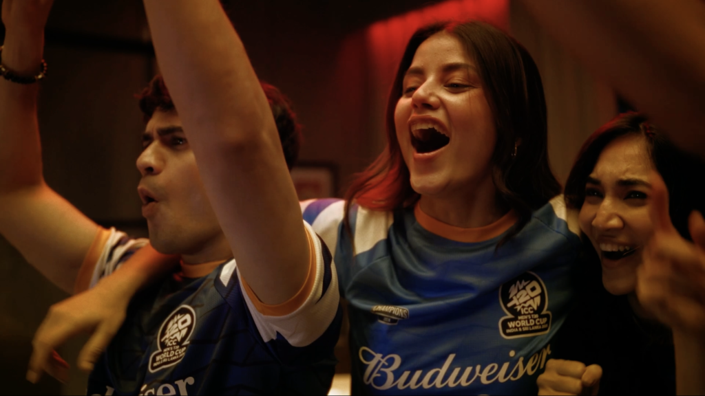 Three fans with arms around shoulders cheering