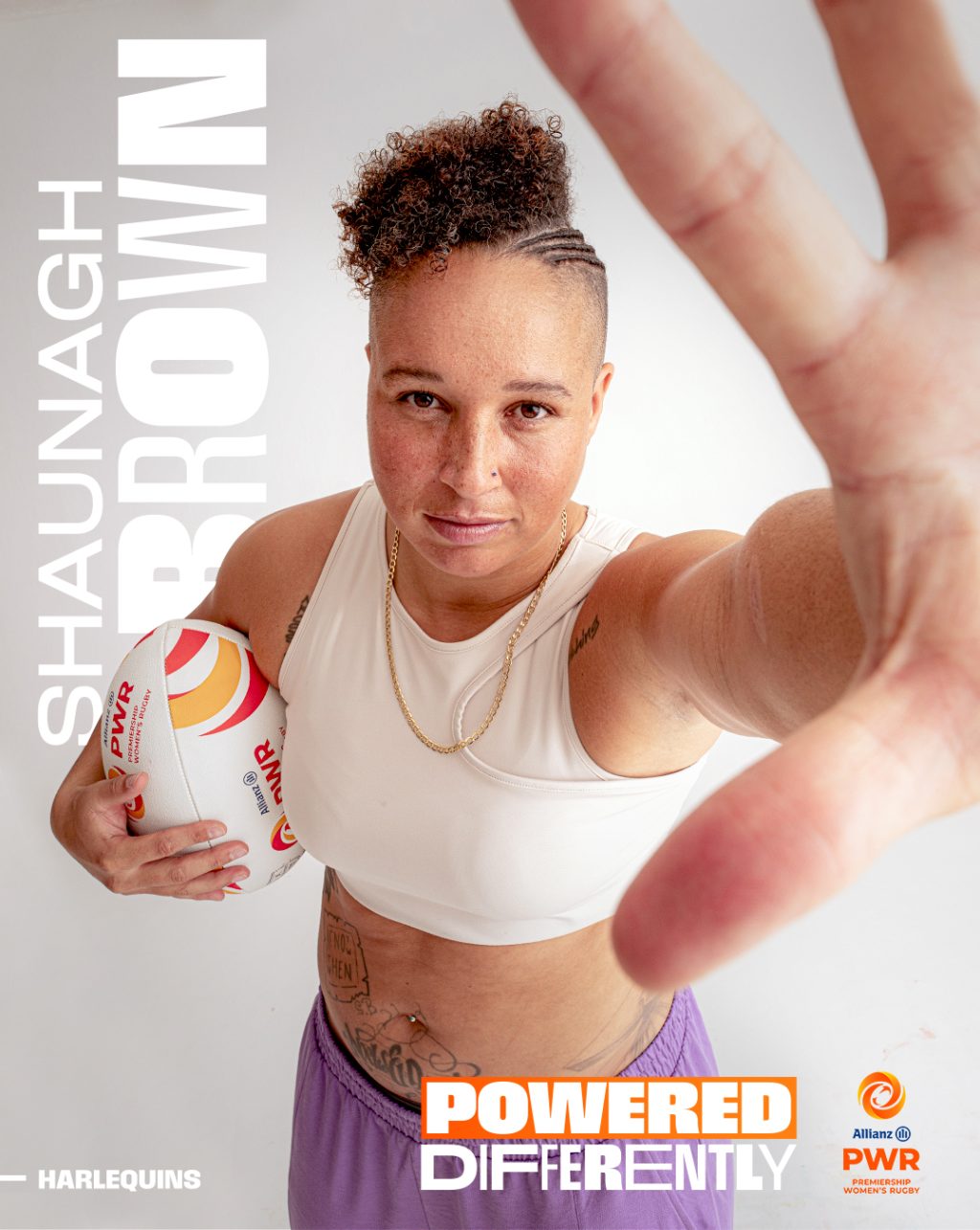 Shaunagh Brown looking into camera with her hand towards the camera and a PWR rugby ball in her arm