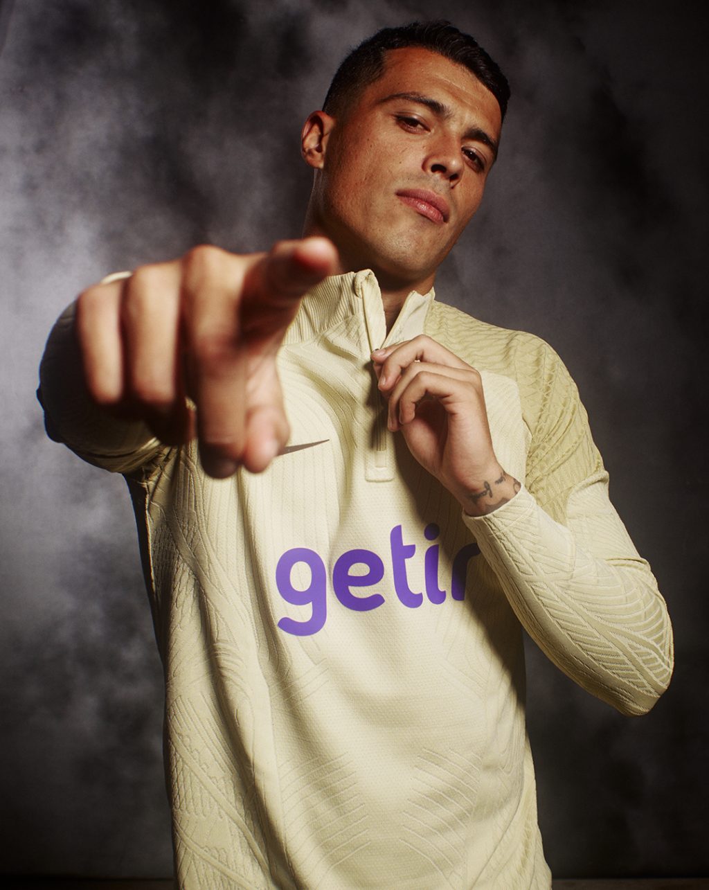 Porro wearing Tottenham Hotspurs training kit and pointing at the camera on a black and white studio background